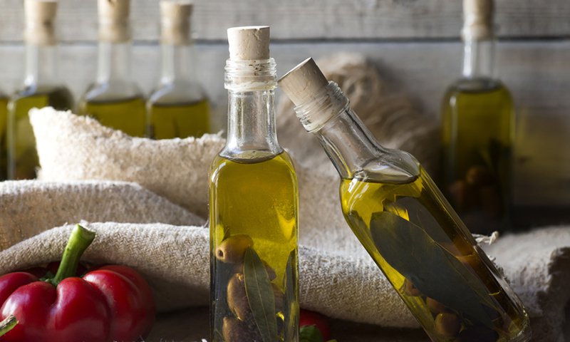 olives and olive oil in mini bottle on wood table